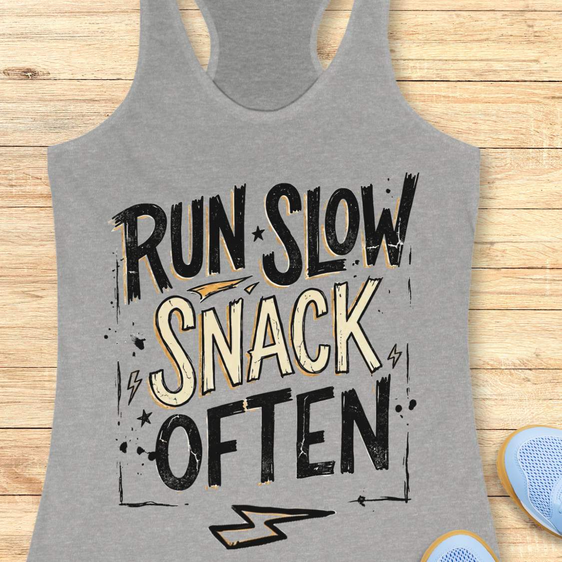 Gray tank top with 'Run Slow, Snack Often' text on a wooden surface