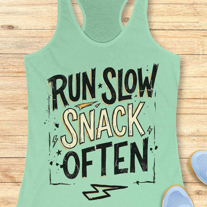 Mint green tank top with 'Run Slow, Snack Often' text on a wooden surface.
