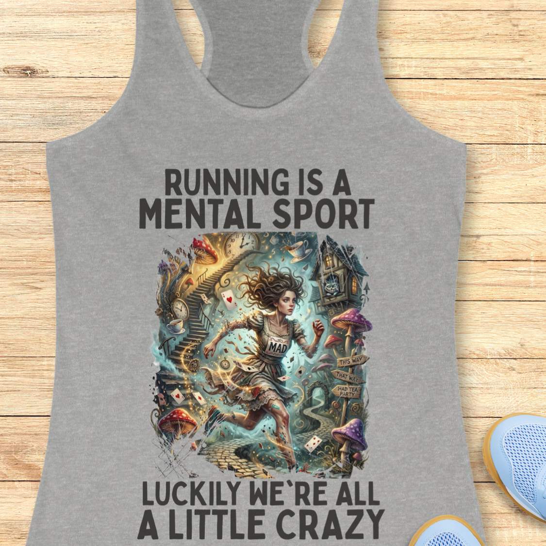 Gray  tank top with graphic design and text 'Running is a mental sport luckily we're all a little crazy' on a wooden surface.