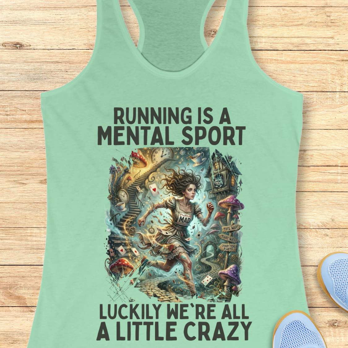 Mint green  tank top with graphic design and text 'Running is a mental sport luckily we're all a little crazy' on a wooden surface.