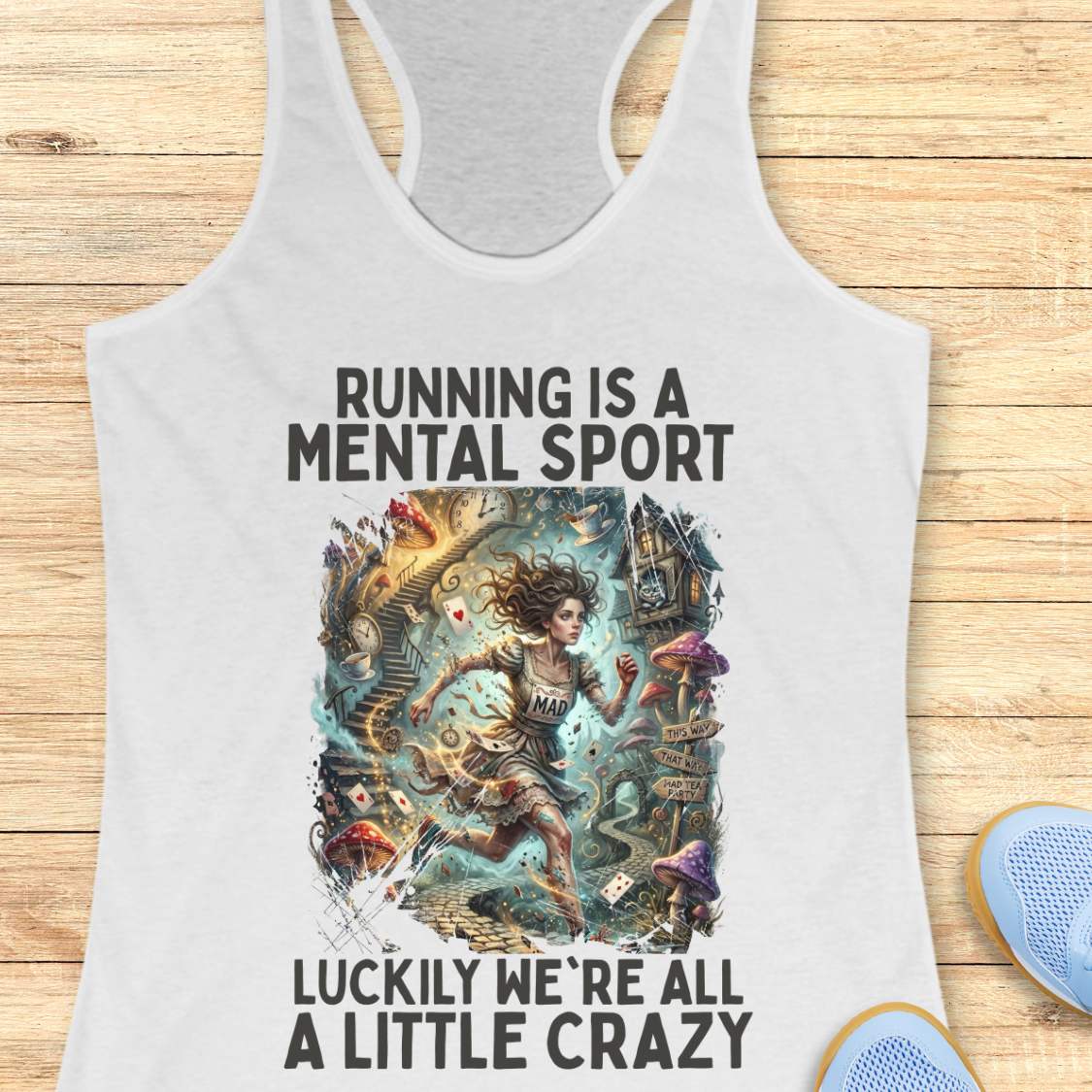 White  tank top with graphic design and text 'Running is a mental sport luckily we're all a little crazy' on a wooden surface.
