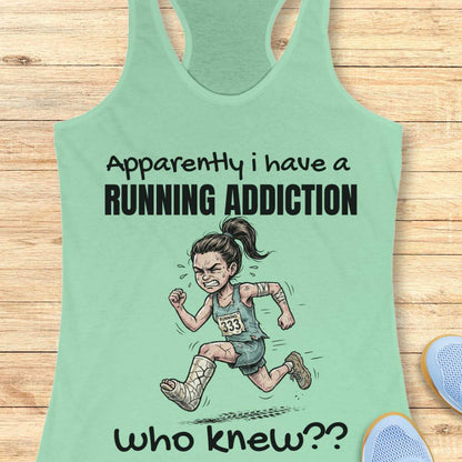Mint green tank top with running-themed design and text 'apparently I have a running addiction. who knew??' on a wooden surface.