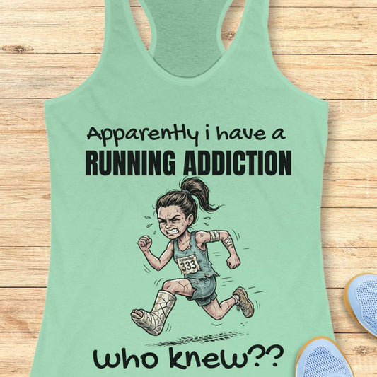 Mint green tank top with running-themed design and text 'apparently I have a running addiction. who knew??' on a wooden surface.