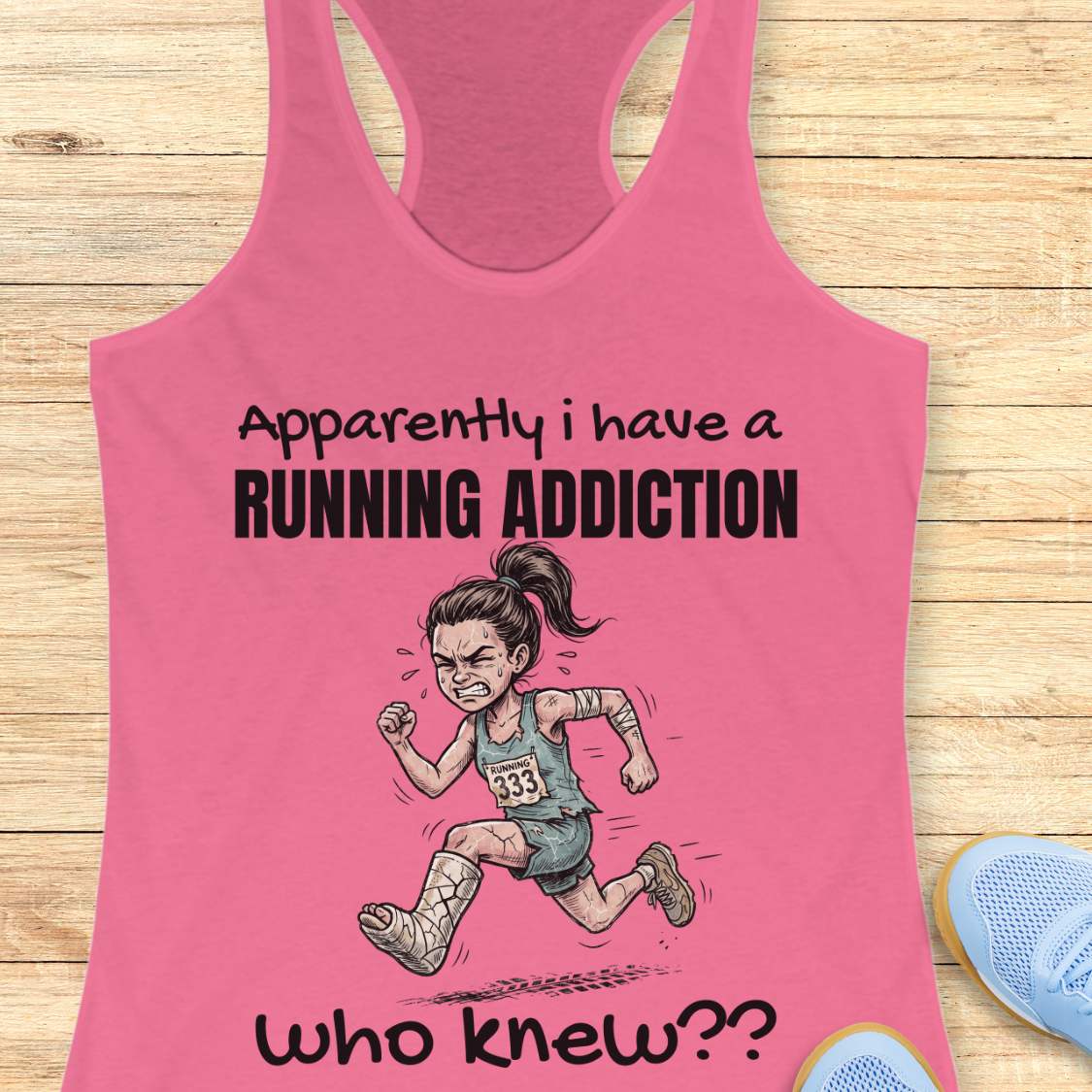 Pink tank top with running-themed design and text  'apparently I have a running addiction. who knew??'  on a wooden surface