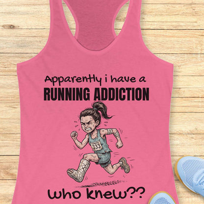 Pink tank top with running-themed design and text  'apparently I have a running addiction. who knew??'  on a wooden surface