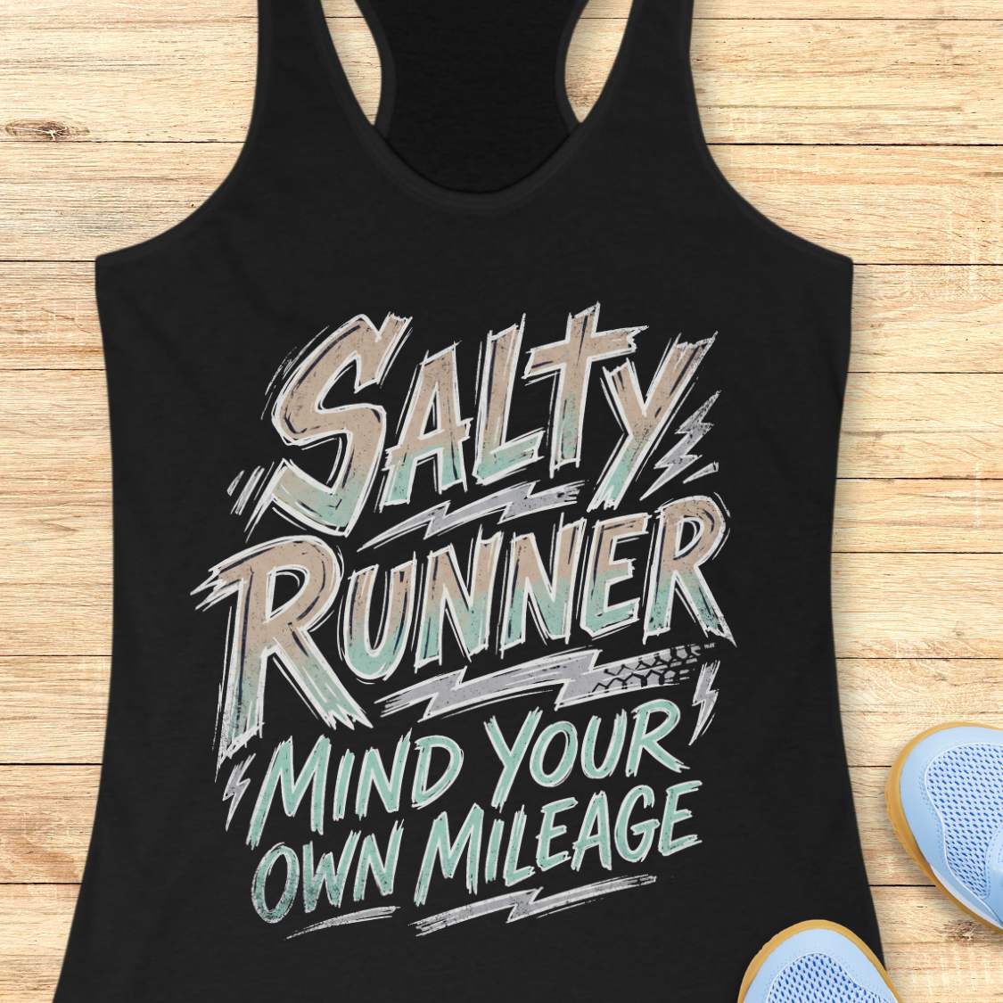 Black tank top with 'Salty Runner Mind Your Own Mileage' text on a wooden surface