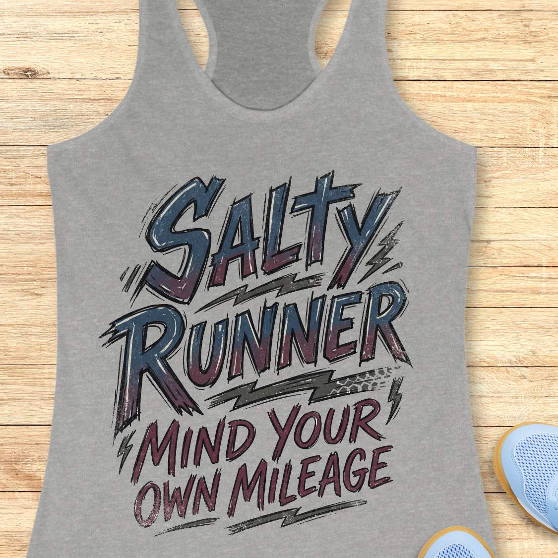 Gray tank top with 'Salty Runner Mind Your Own Mileage' text on a wooden surface