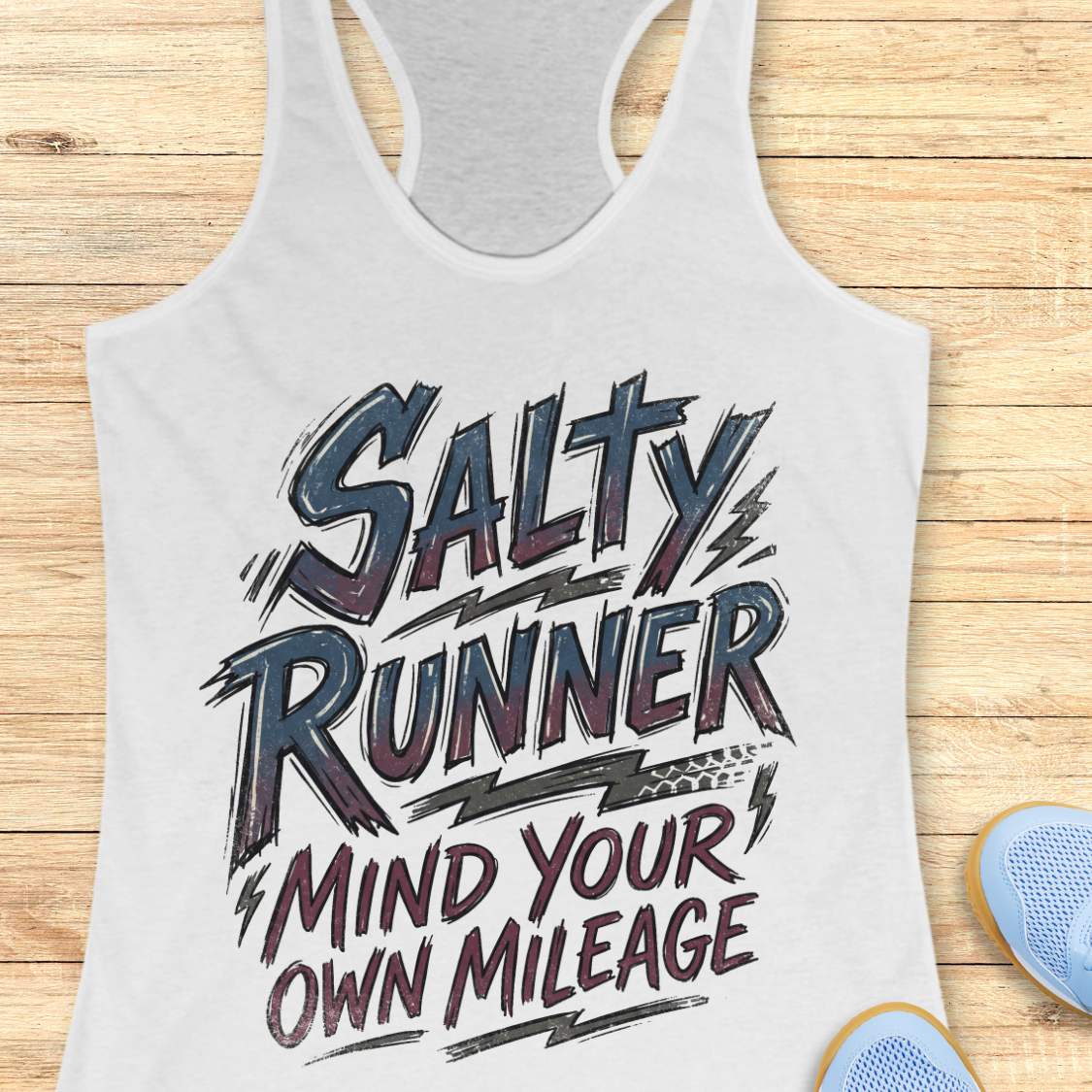 white tank top with 'Salty Runner Mind Your Own Mileage' text on a wooden surface.