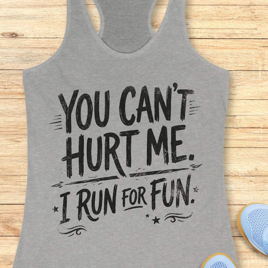 Gray tank top with humorous text 'You can't hurt me. I run for fun.' on a wooden surface