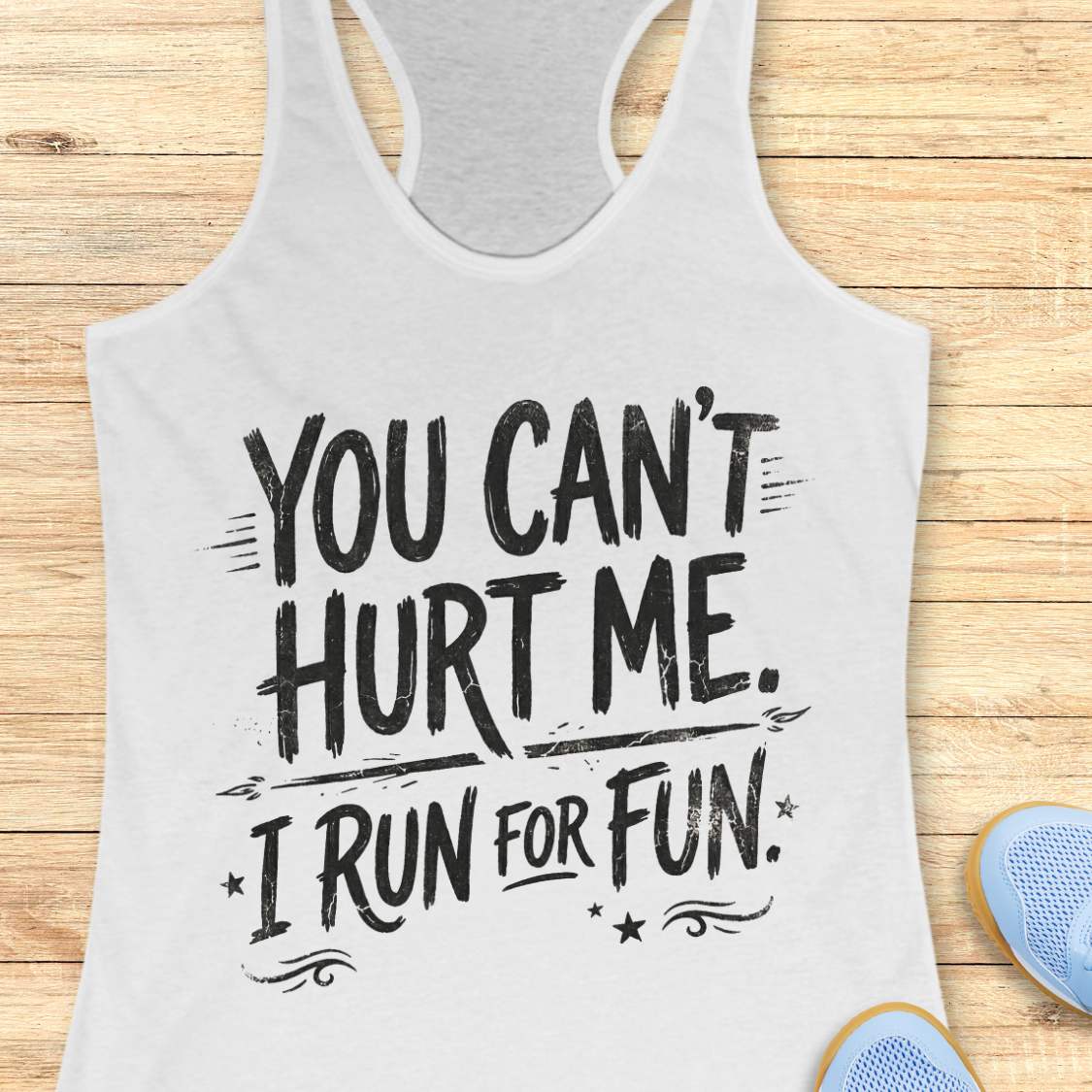 white tank top with text 'You can't hurt me. I run for fun' on a wooden surface.