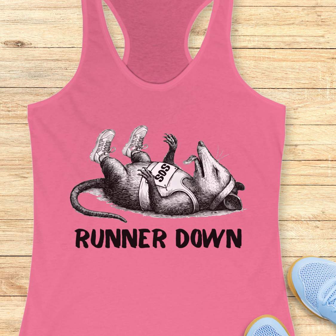 Pink tank top with a graphic of a rat wearing running shoes and the text 'Runner Down' on a wooden surface.