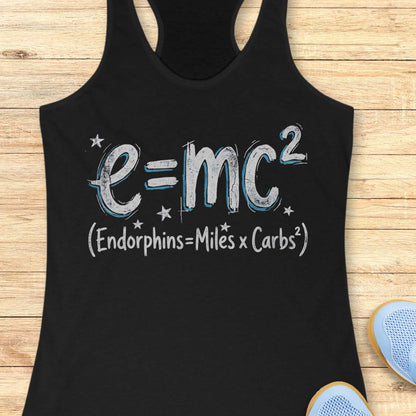 Black tank top with a humorous equation printed on it, with text - 'Endorphins = Miles X Carbs square' placed on a wooden surface.