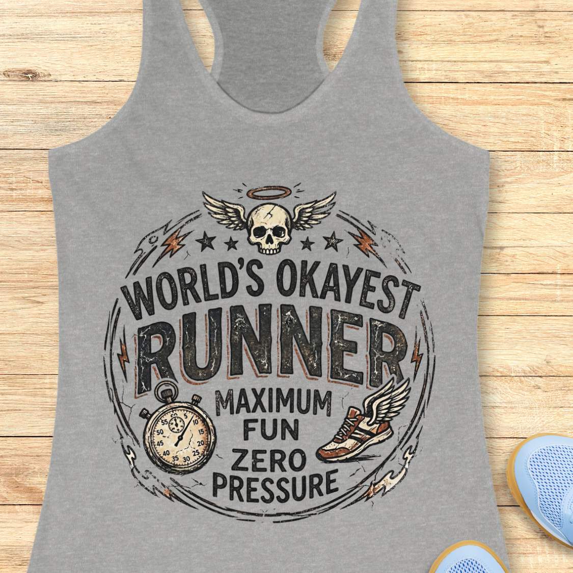 Gray tank top with  'World's Okayest Runner maximum fun, zero pressure'  graphic on a wooden surface