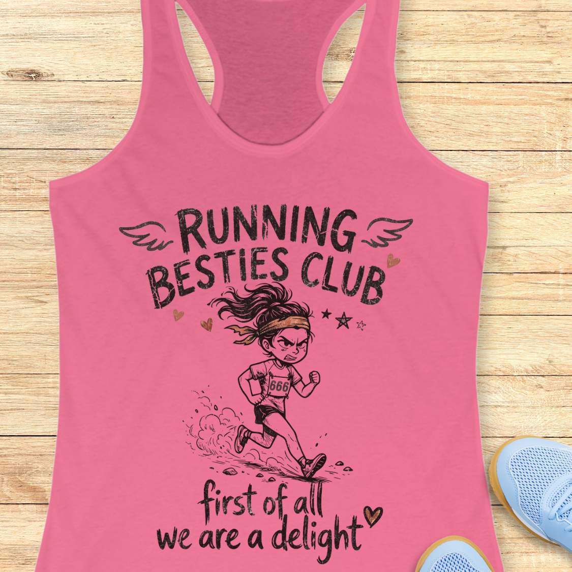 Pink tank top with 'Running Besties Club' design on a wooden surface
