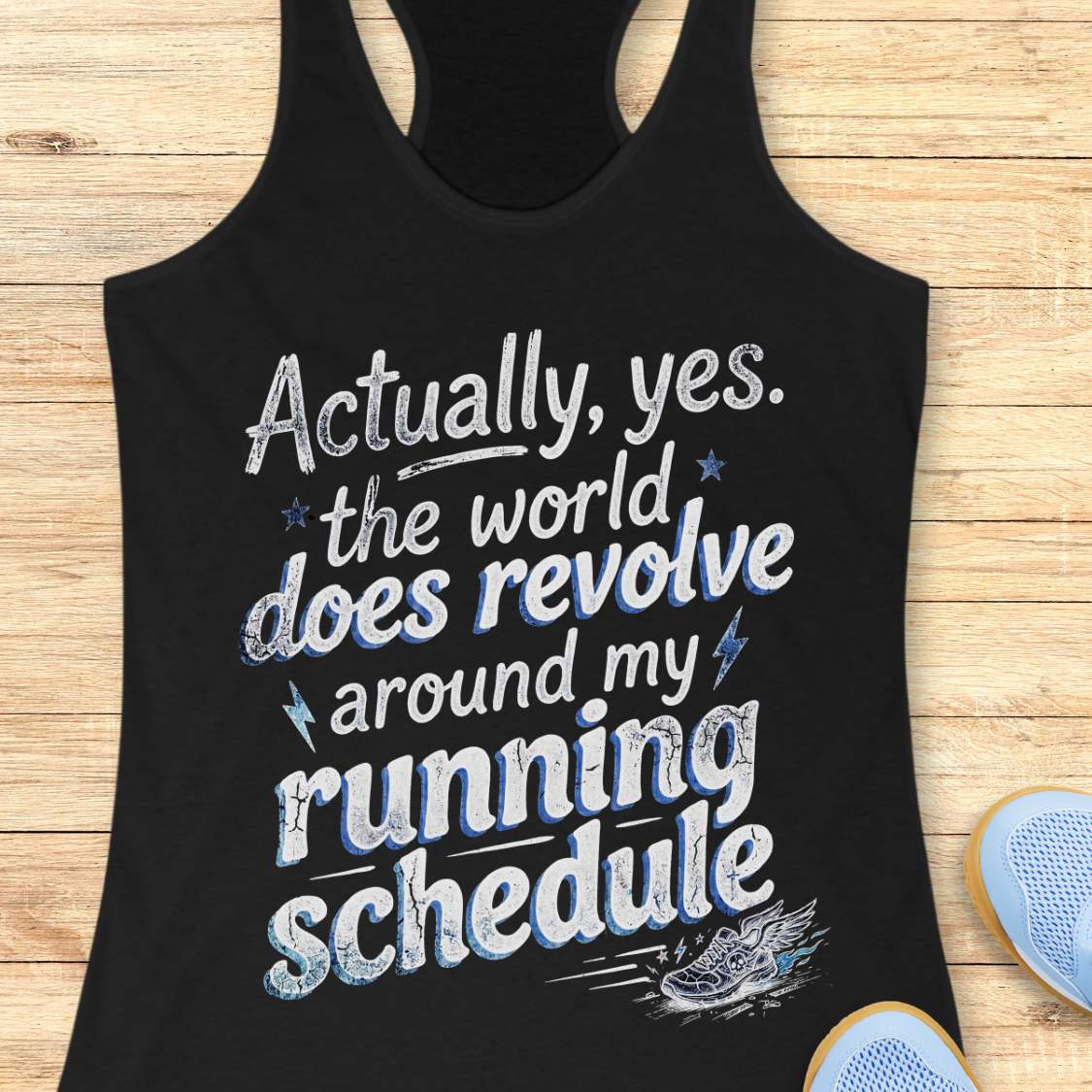 Black tank top with funny text 'Actually, yes. the world does revolve around my running schedule.',  on a wooden surface