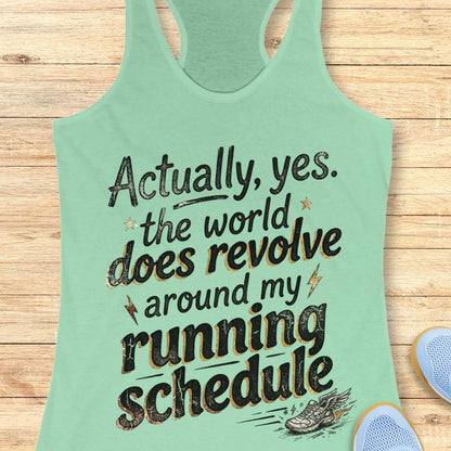 Mint green tank top with funny text 'Actually, yes. the world does revolve around my running schedule.',  on a wooden surface