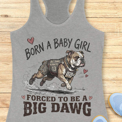 Gray tank top with bulldog graphic and text 'Born a baby girl forced to be a BIG DAWG', on a wooden surface