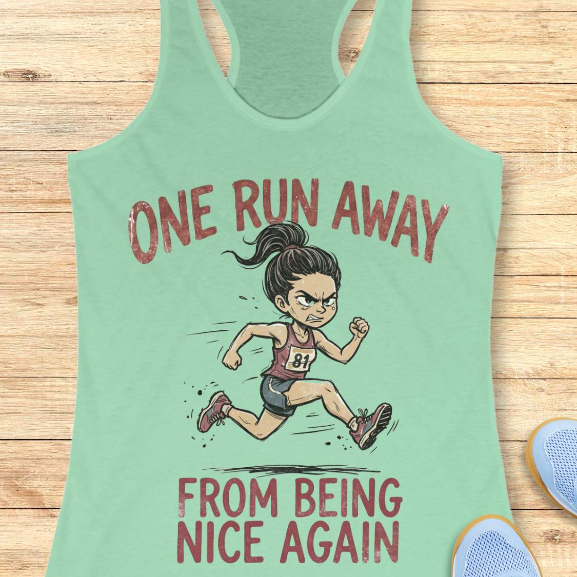 Mint green tank top with a cartoon runner and text 'one run away from being nice again',  on a wooden surface