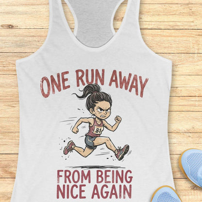 white tank top with a graphic of a running woman and text 'one run away from being nice again', on a wooden surface