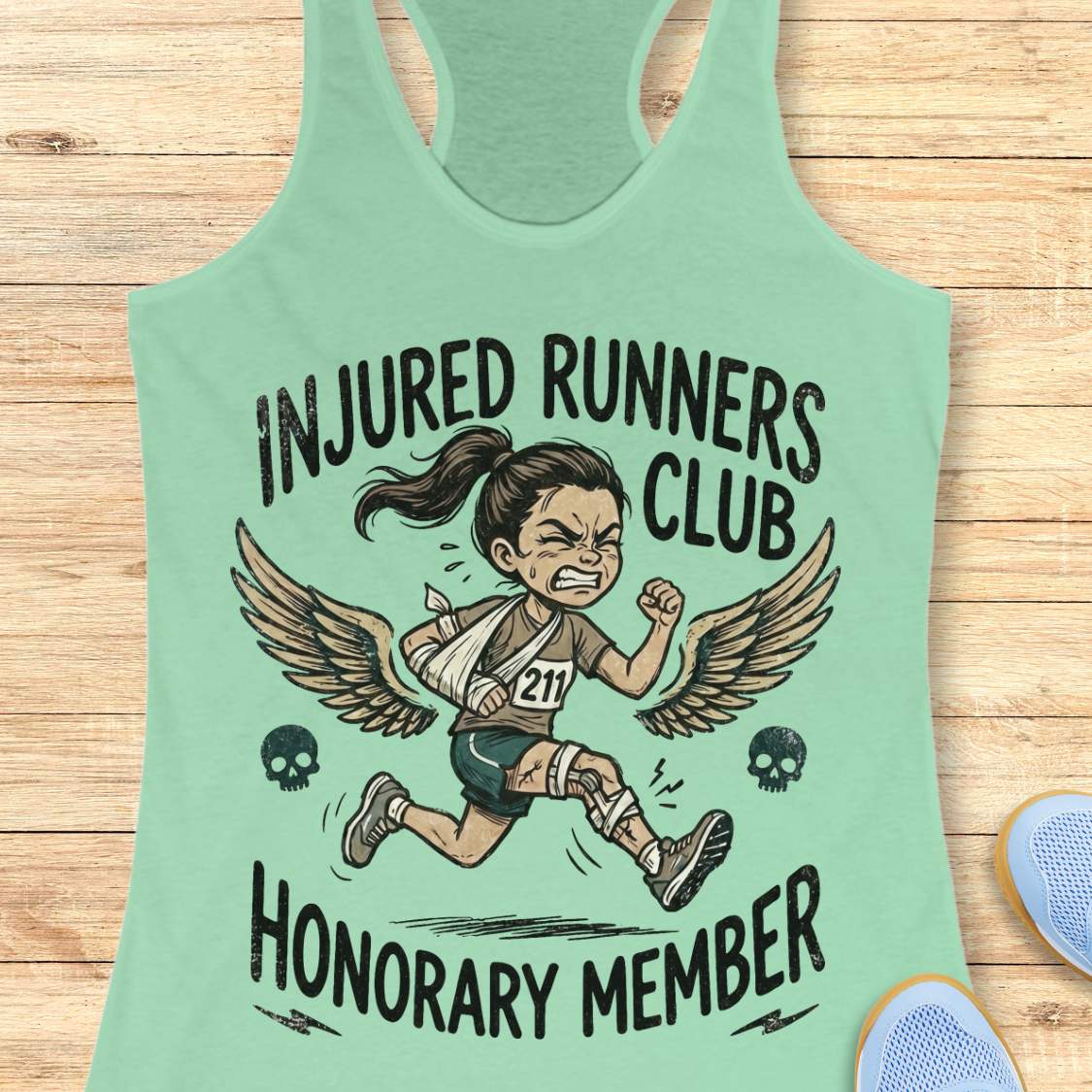 Mint green tank top with 'Injured Runners Club Honorary Member' graphic on a wooden surface.