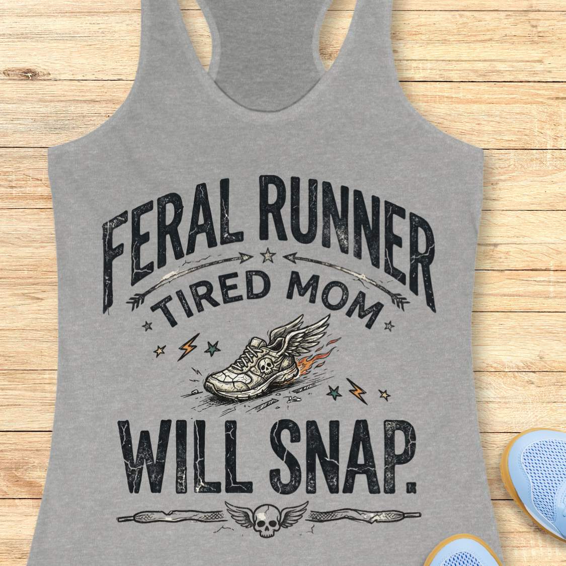 Gray tank top with 'Feral Runner Tired Mom Will Snap' text and graphic on a wooden surface