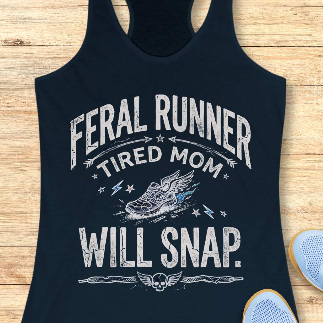 navy tank top with 'Feral Runner Tired Mom Will Snap' text and graphic on a wooden surface.