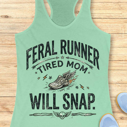 Mint green tank top with text 'feral runner, tired mom, will snap.' , and graphic design on a wooden surface