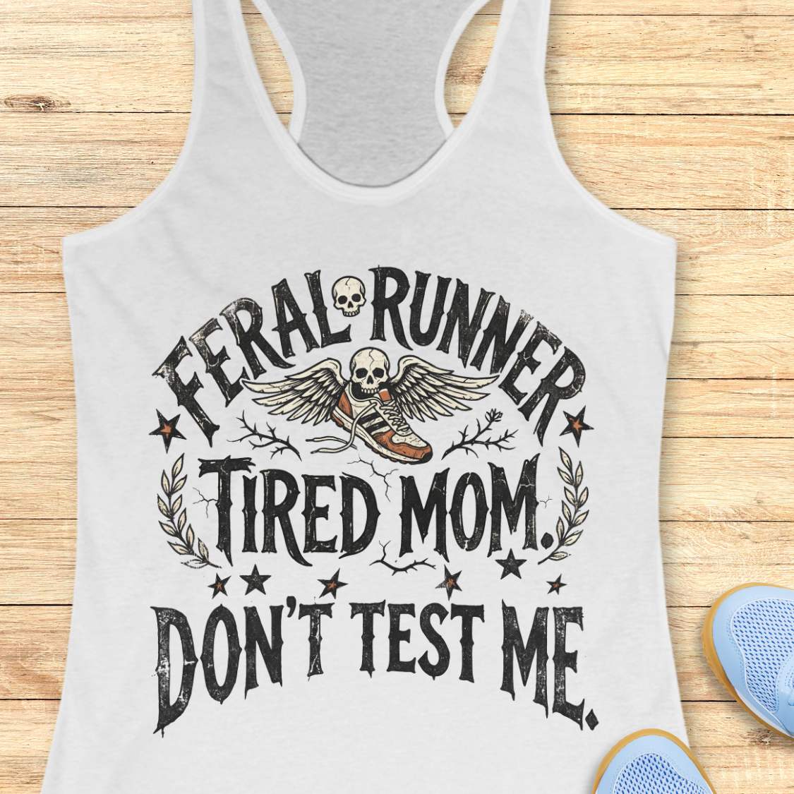 white tank top with 'Feral Runner Tired Mom Don't Test Me' text on a wooden surface