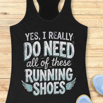 Black tank top with motivational text ' yes, I really do need all of these running shoes', on a wooden surface
