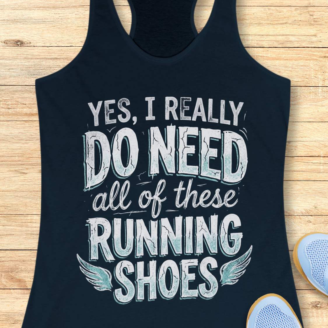 navy tank top with text 'Yes, I really do need all of these running shoes' on a wooden surface.