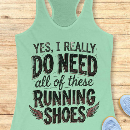 Light green tank top with text ' yes, I really do need all of these running shoes', on a wooden surface