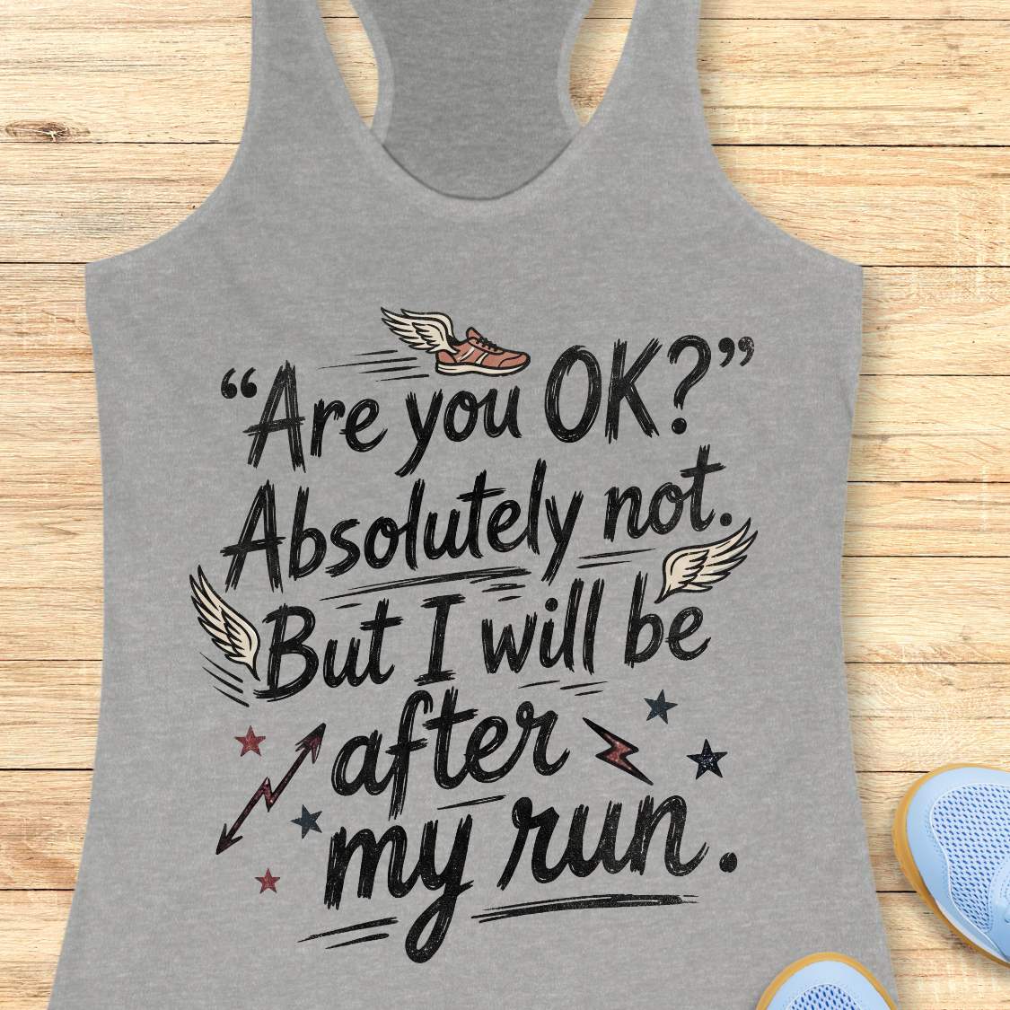 Gray tank top with humorous running text 'Are you ok? Absolutely not. But I will be after my run.', design on a wooden surface