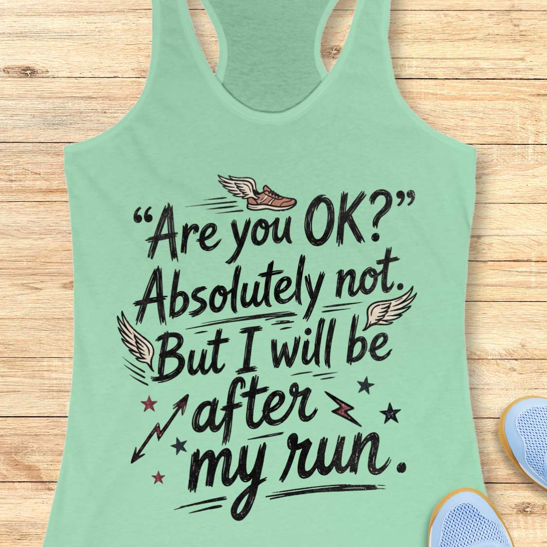 Light green tank top with humorous text 'Are you ok? Absolutely not. But I will be after my run.', design on a wooden surface