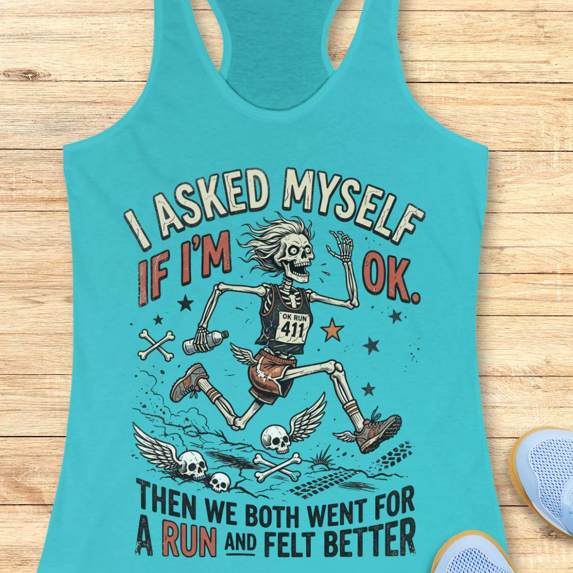 Turquoise tank top with skeleton graphic and text 'I asked myself if I'm OK. Then we both went for a run and felt better',  on a wooden surface