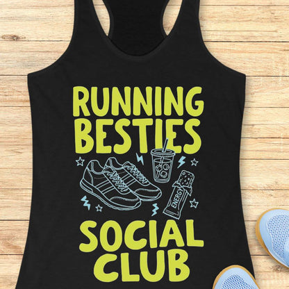 Black tank top with 'Running Besties Social Club' text and graphics on a wooden surface.