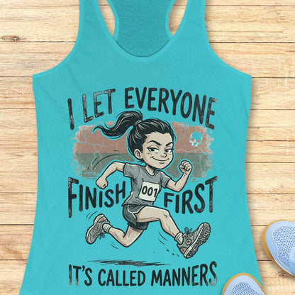 Turquoise tank top with a graphic of a runner and text  'I let everyone finish first. It's called manners', on a wooden surface
