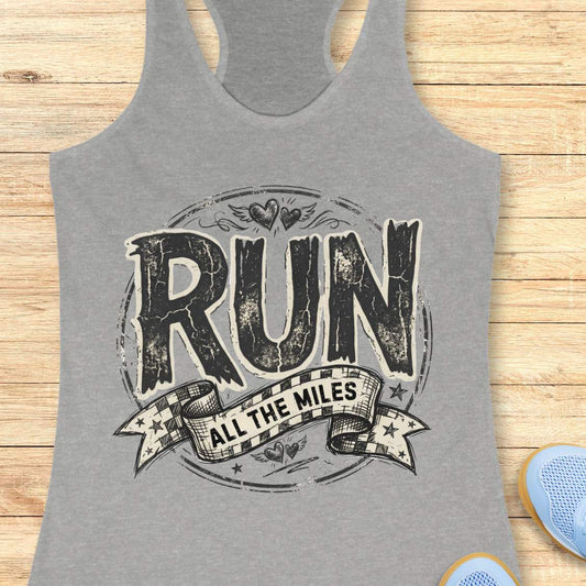 Gray tank top with 'RUN ALL THE MILES' text on a wooden surface