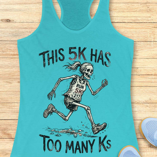 Turquoise tank top with skeleton running design and text 'This 5k has too many Ks', on a wooden surface