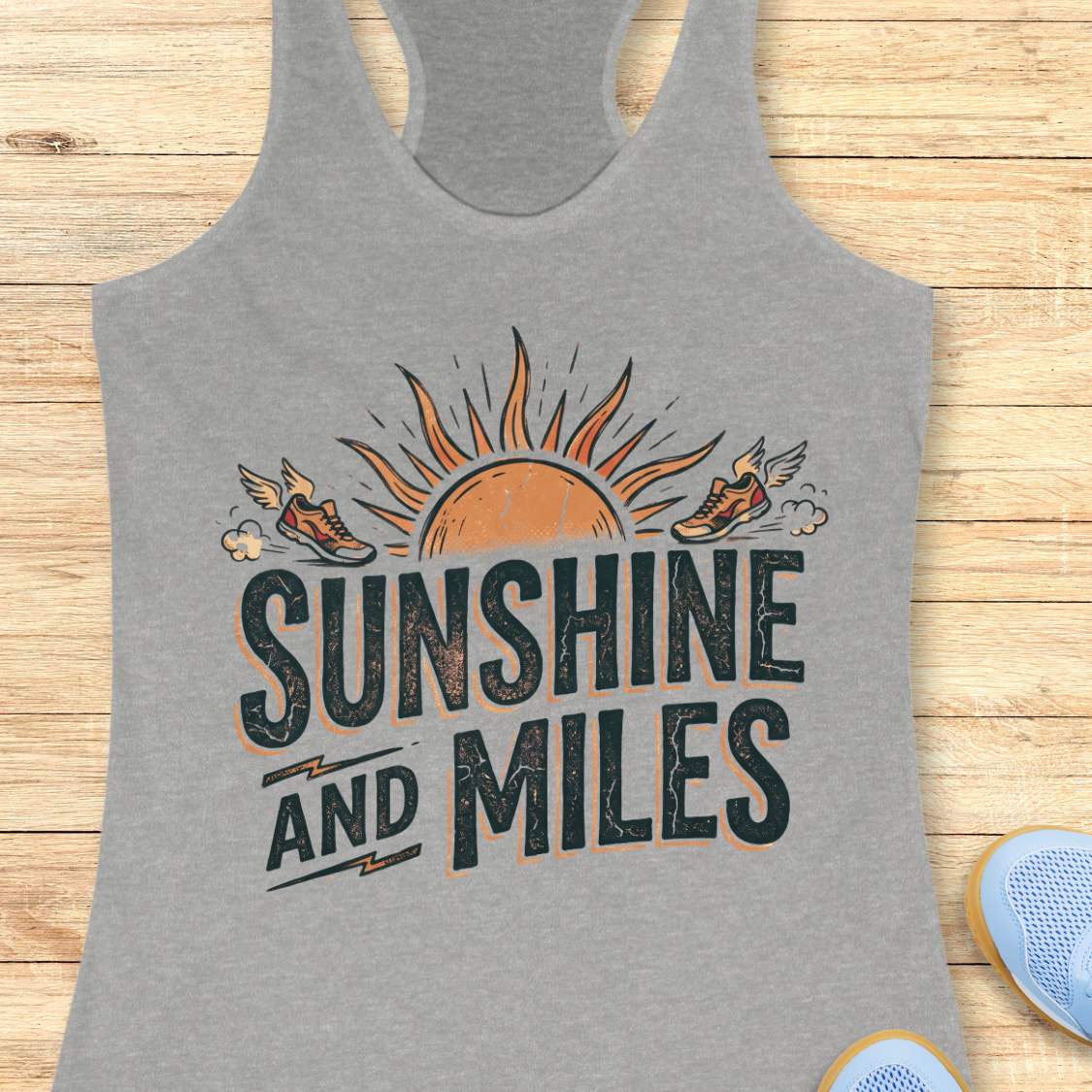 Gray tank top with 'Sunshine and Miles' design on a wooden surface