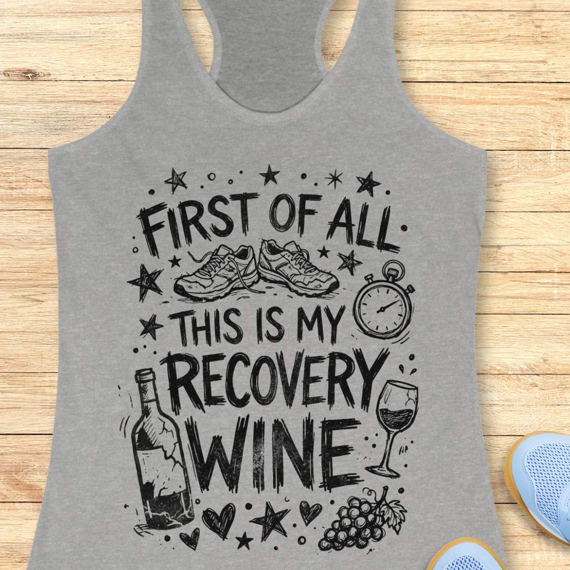 Gray tank top with 'first of all, this is my recovery wine', graphic design on a wooden surface