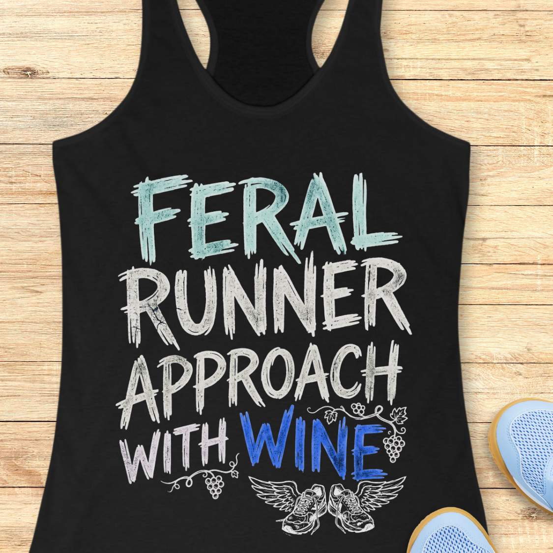 black tank top with black graphic design and text 'feral runner approach with wine', on a wooden surface