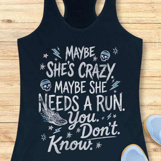 navy tank top with black graphic design and text 'maybe she's crazy, maybe she needs a run. you. don't. know.', on a wooden surface