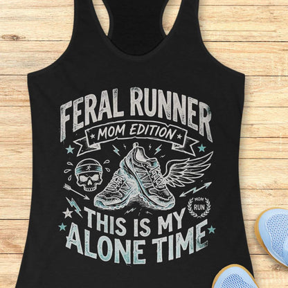 black tank top with black graphic design and text 'feral runner, mom edition. This is my alone time', on a wooden surface