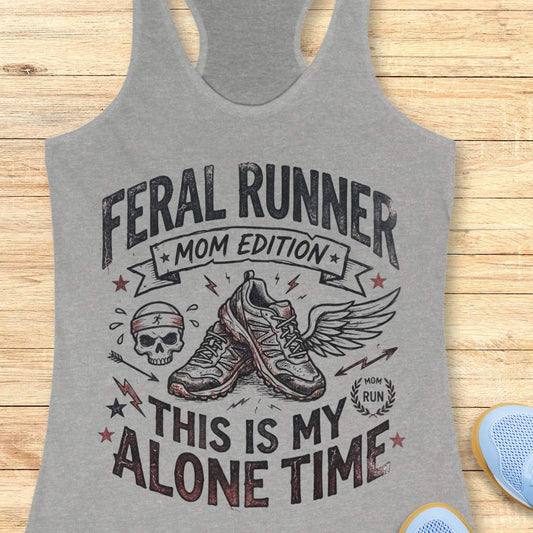 grey tank top with black graphic design and text 'feral runner, mom edition. This is my alone time', on a wooden surface
