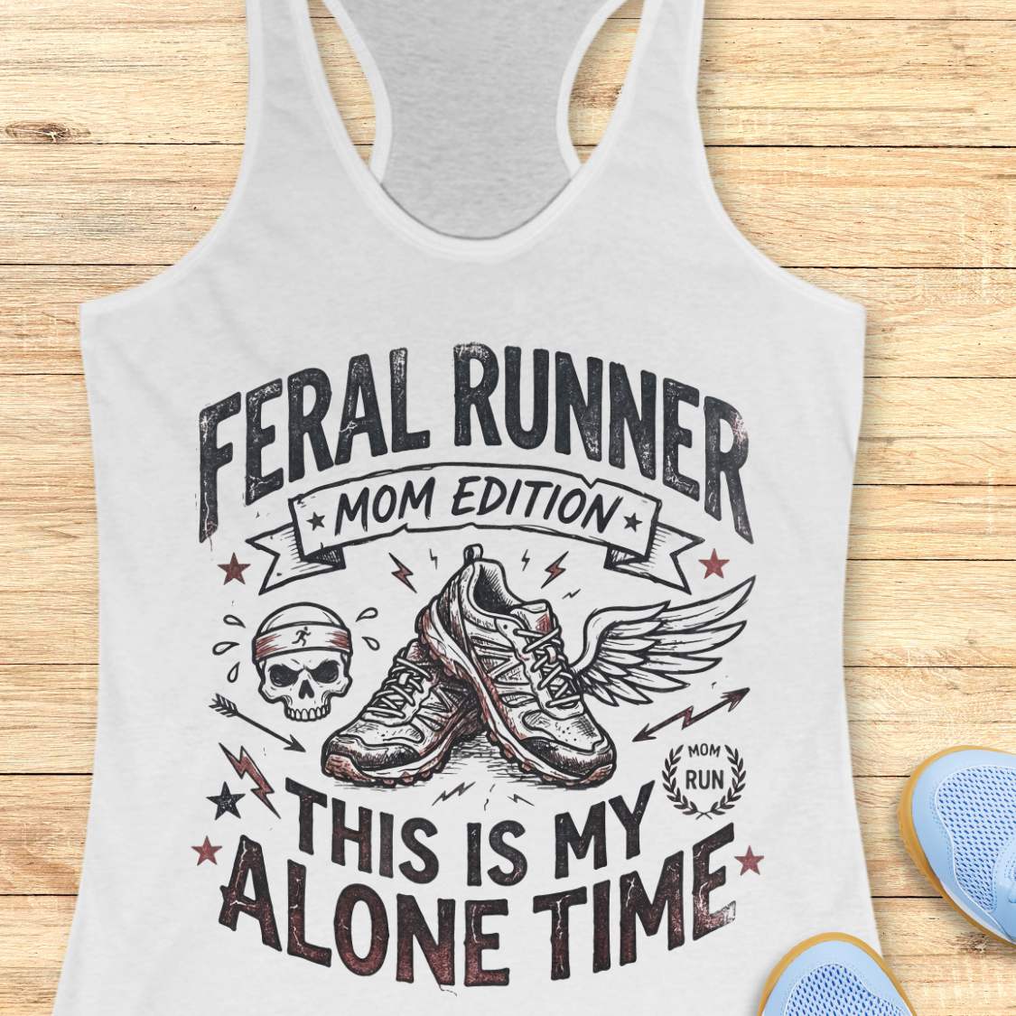white tank top with black graphic design and text 'feral runner, mom edition. This is my alone time', on a wooden surface