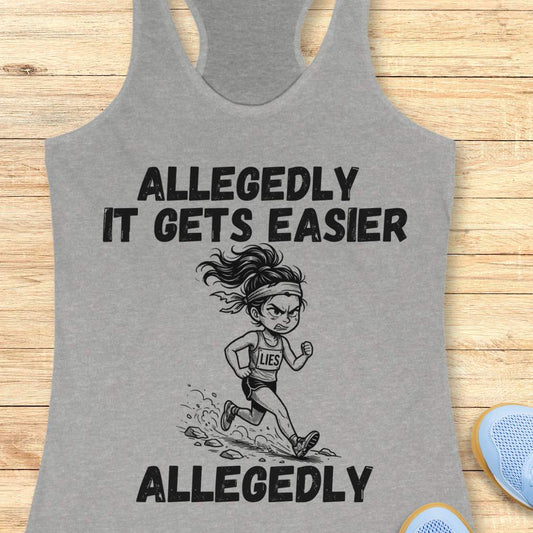 grey tank top with black graphic design and text 'allegedly it gets easier. Allegedly.', on a wooden surface