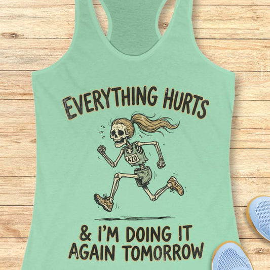 mint tank top with graphic design of a runner skeleton and text 'Everything hurts and I'm doing it again tomorrow', on a wooden surface