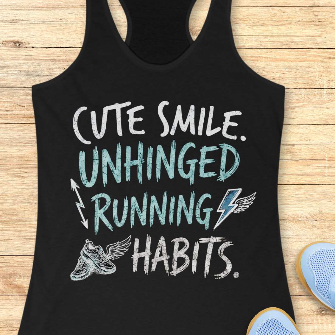black tank top with text 'cute smile unhinged running habits', on a wooden surface