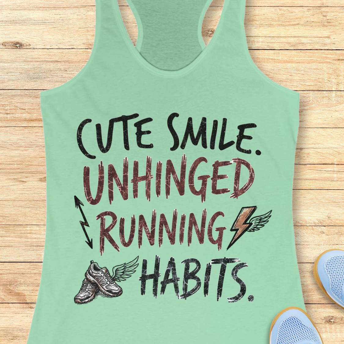 mint tank top with text 'cute smile unhinged running habits', on a wooden surface