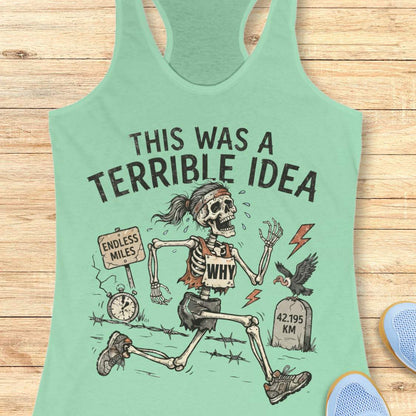 mint tank top with a running skeleton and text 'This was a terrible idea', on a wooden surface